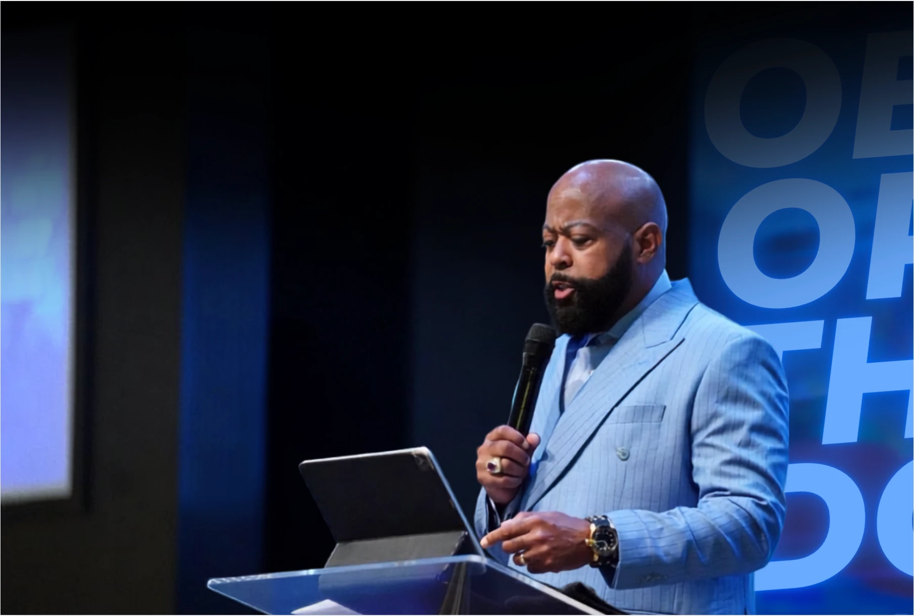 Bishop Dr. Richard Leaphart-Mack speaking at a lectern